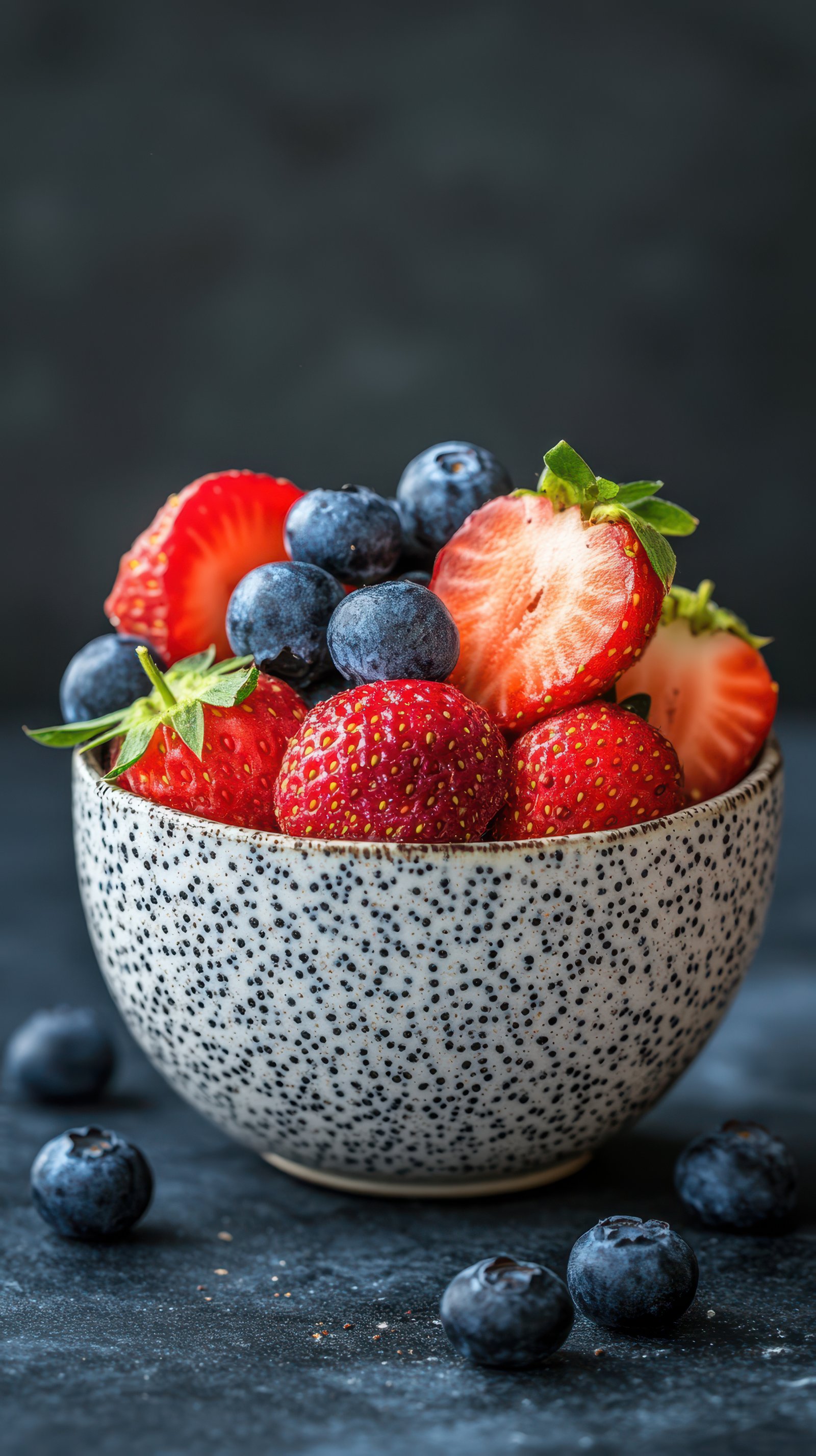 Fresh strawberries and blueberries in a speckled bowl create a vibrant summer treat perfect for snacking or desserts